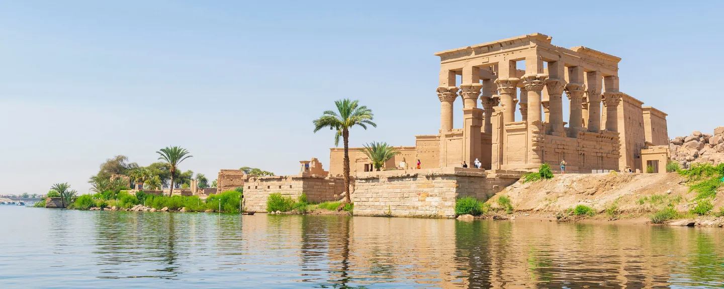 An ancient Egyptian temple overlooking the water of a nearby lake