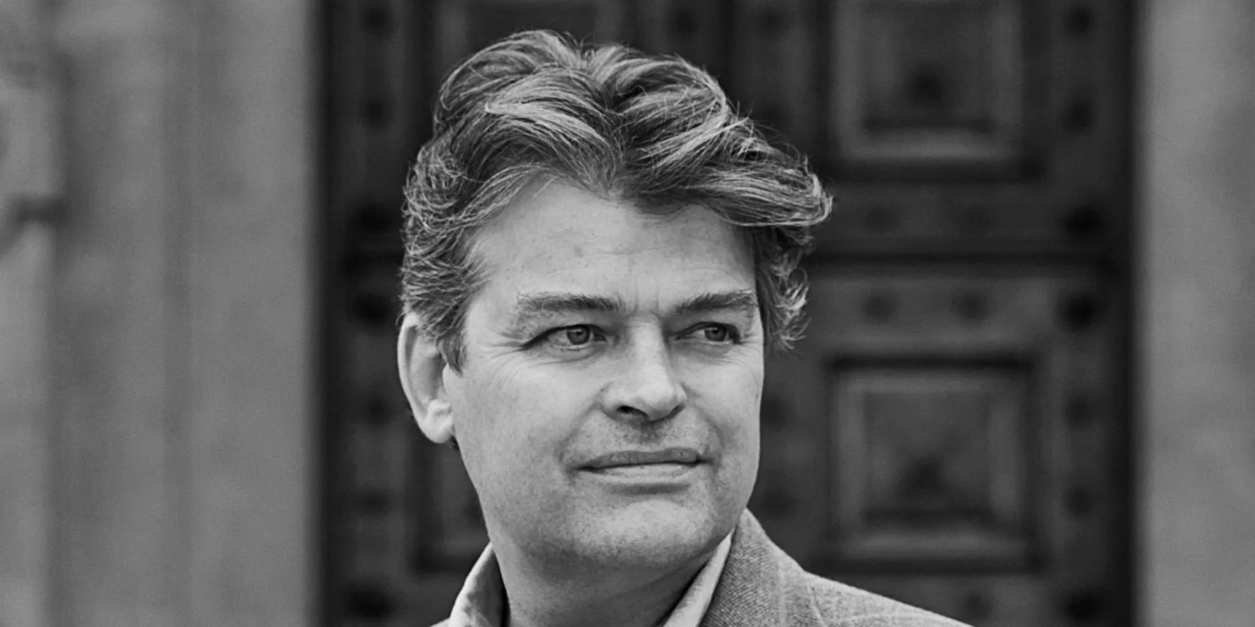 Man in formal attire near ornate door